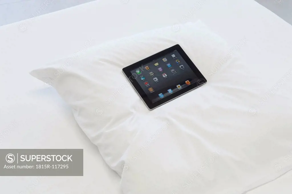 Germany, Digital tablet on white pillow