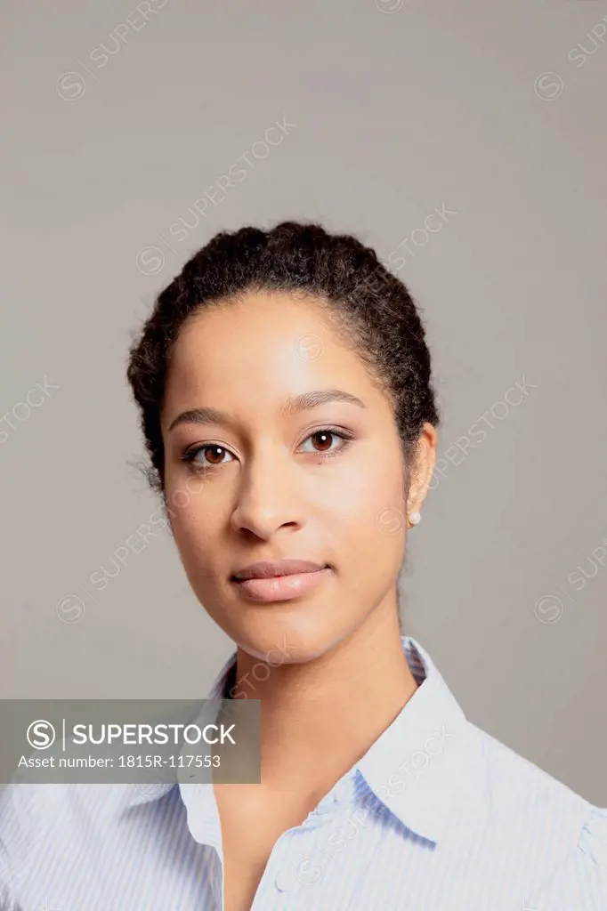 Portrait of young woman against gray background
