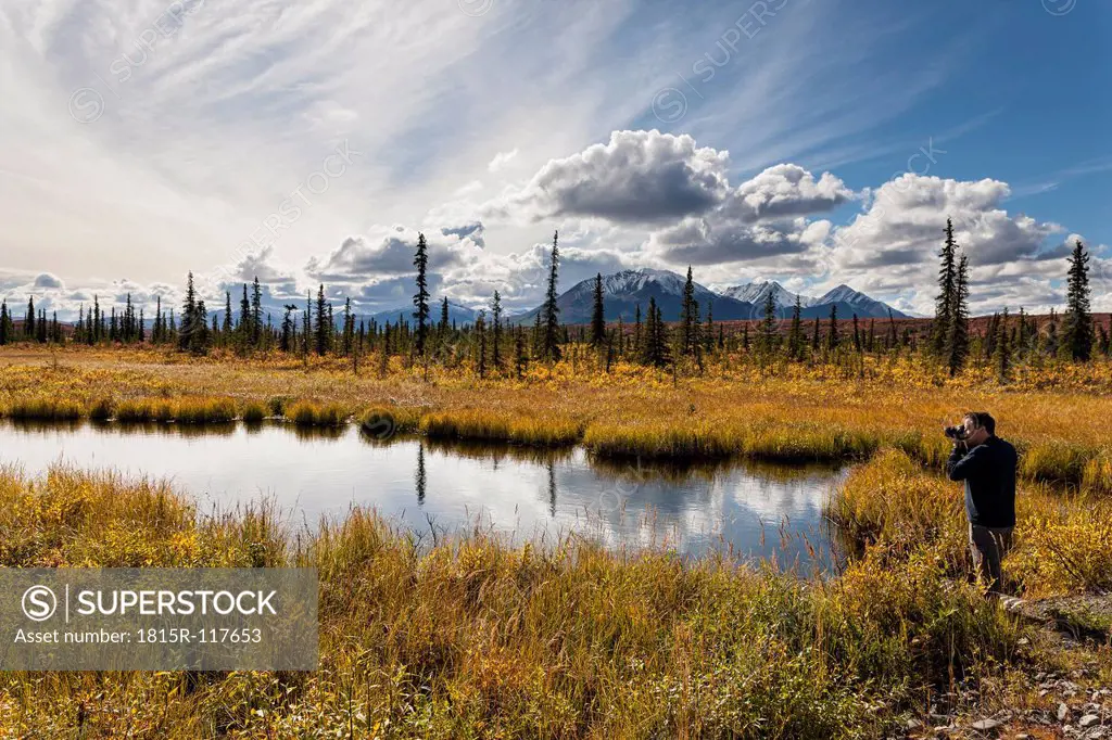 USA, Alaska, Tourist taking photograph of landscape in autumn