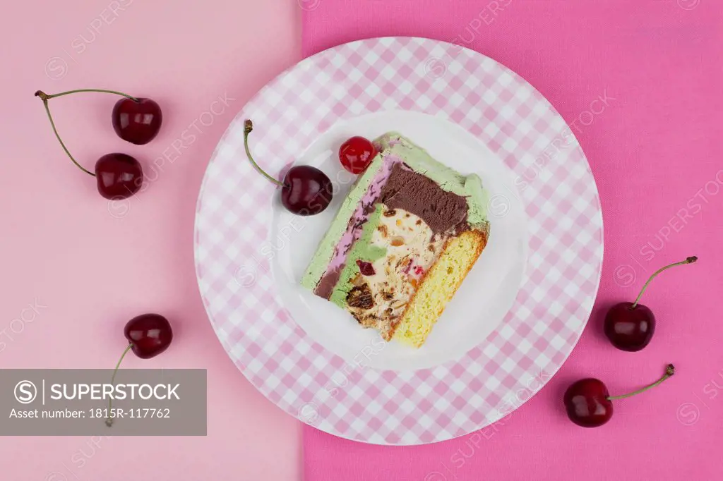 Plate of ice cream cake on pink background