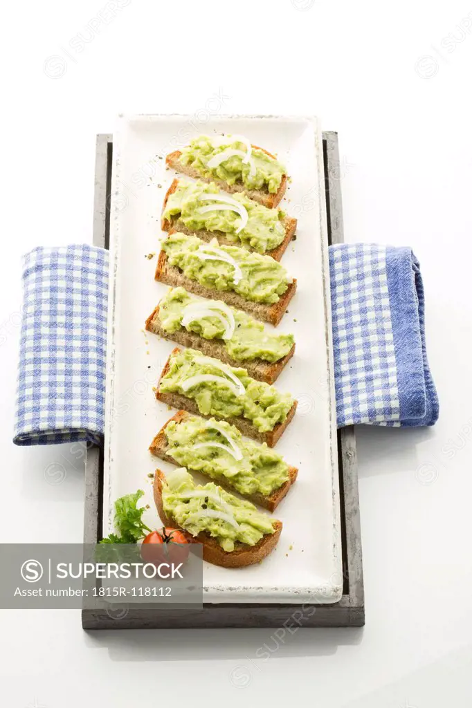 Bread slices with avocado spread on tray