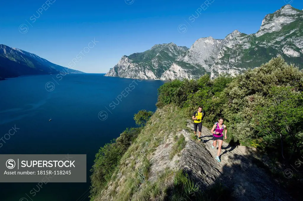 Italy, Mid adult couple jogging by Lake Garda