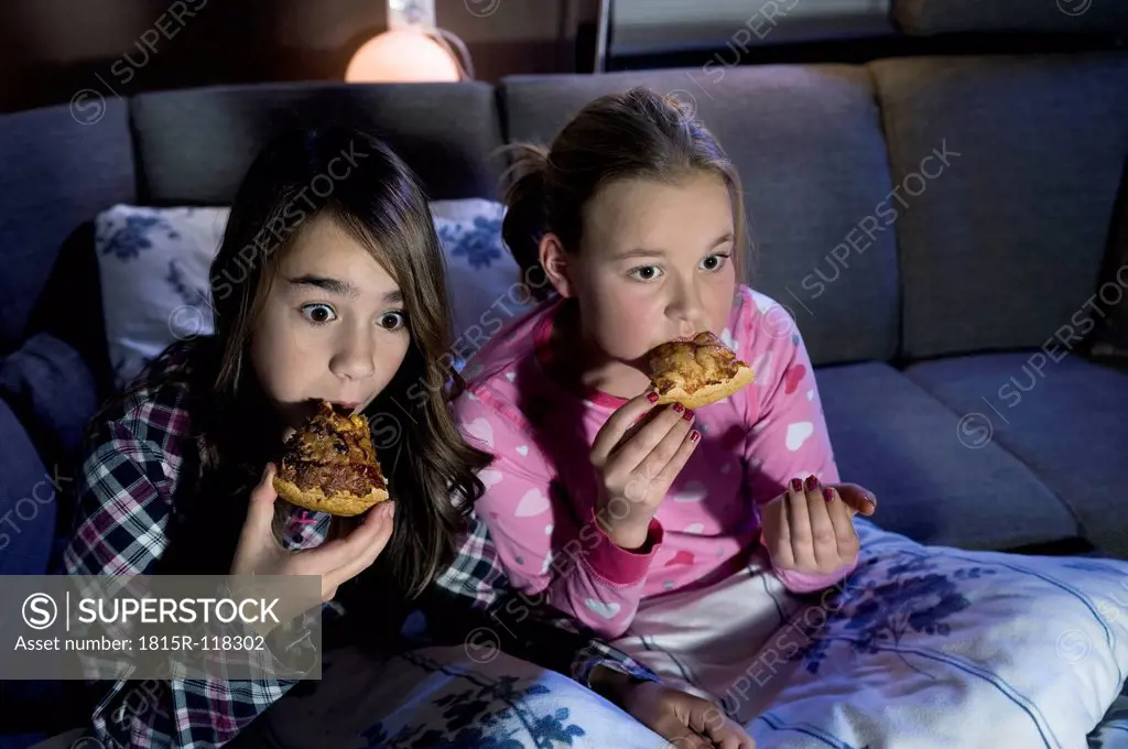 Girls eating pizza while watching scary film