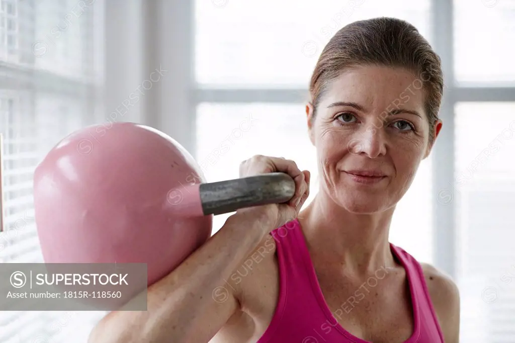 Germany, Duesseldorf, Mature woman exercising with kettlebell
