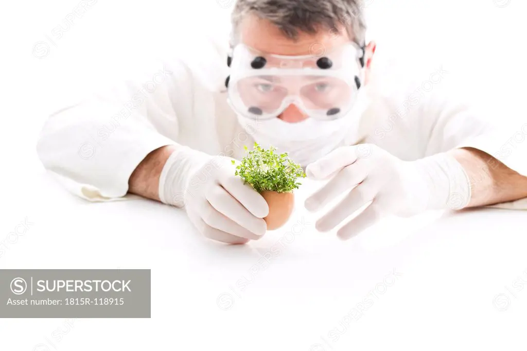 Scientist examining cress in egg shell, close up