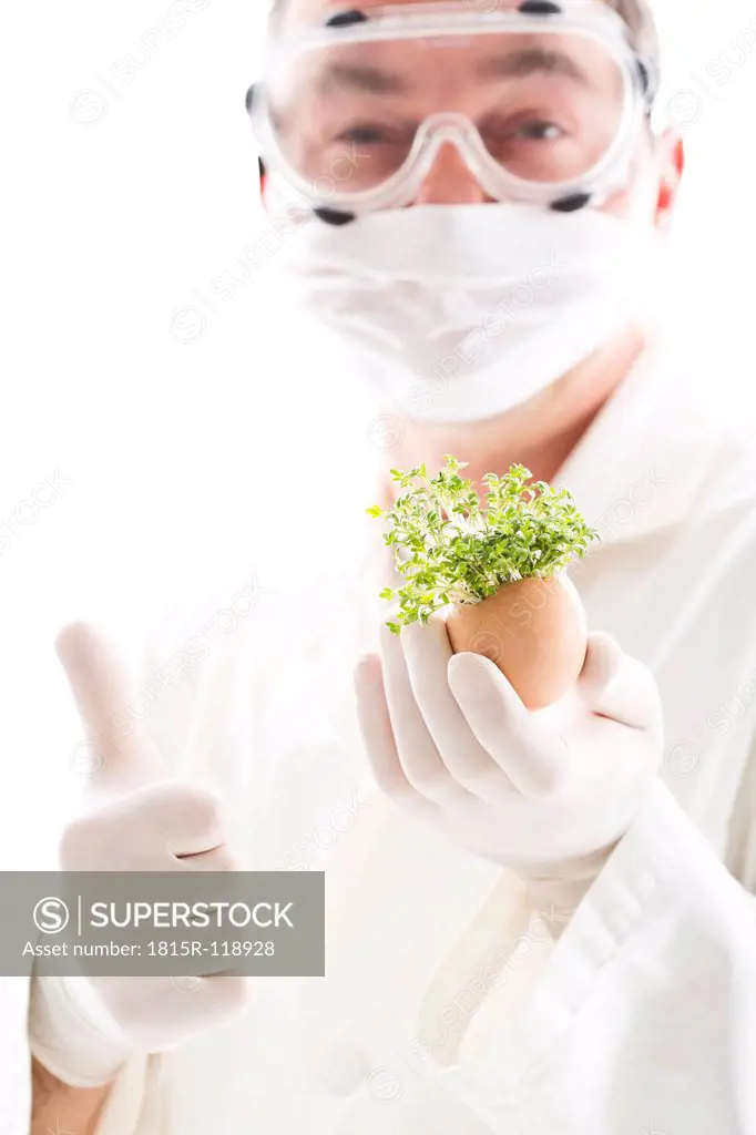 Scientist holding cress in egg shell with thumbs up, close up