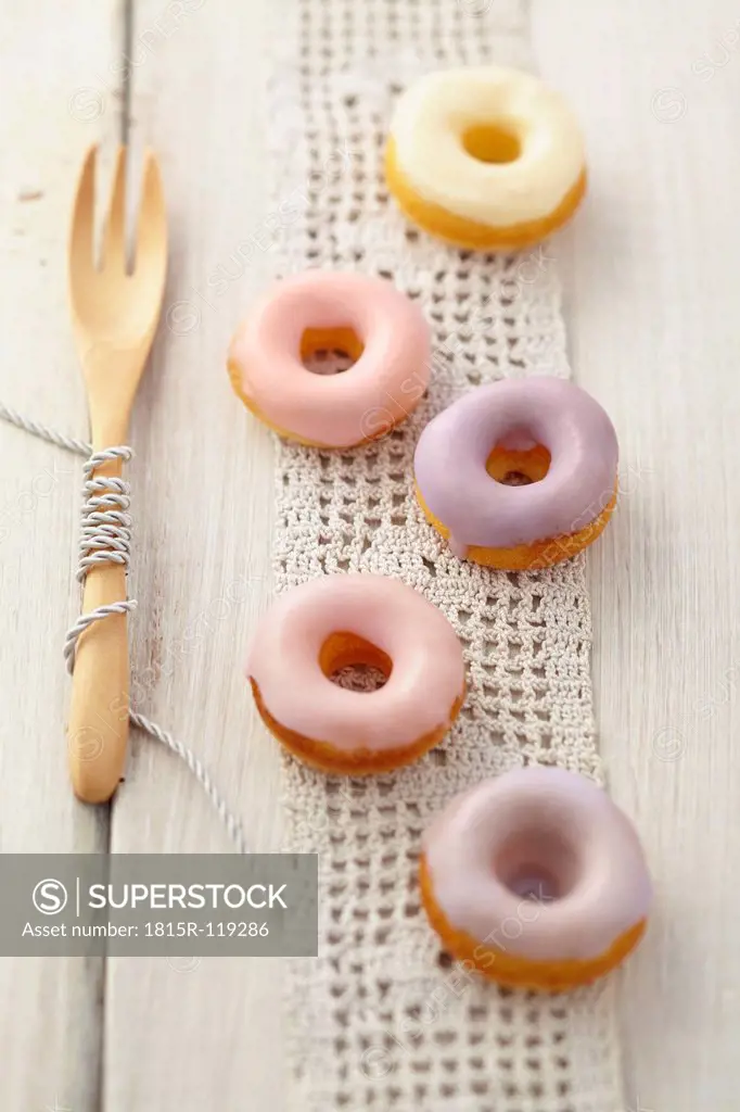 Glazed baked doughnuts with wooden fork on table