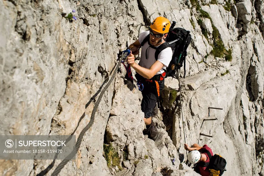Germany, Bavaria, Mountaineer climbing steep wall