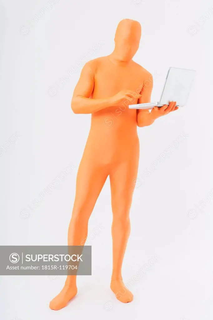 Mature man in orange zentai using laptop on white background