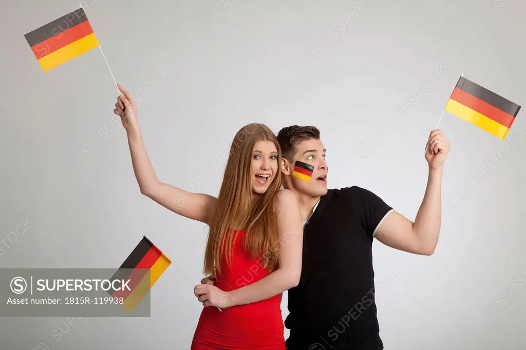 Close up of couple holding German Flag against gray background