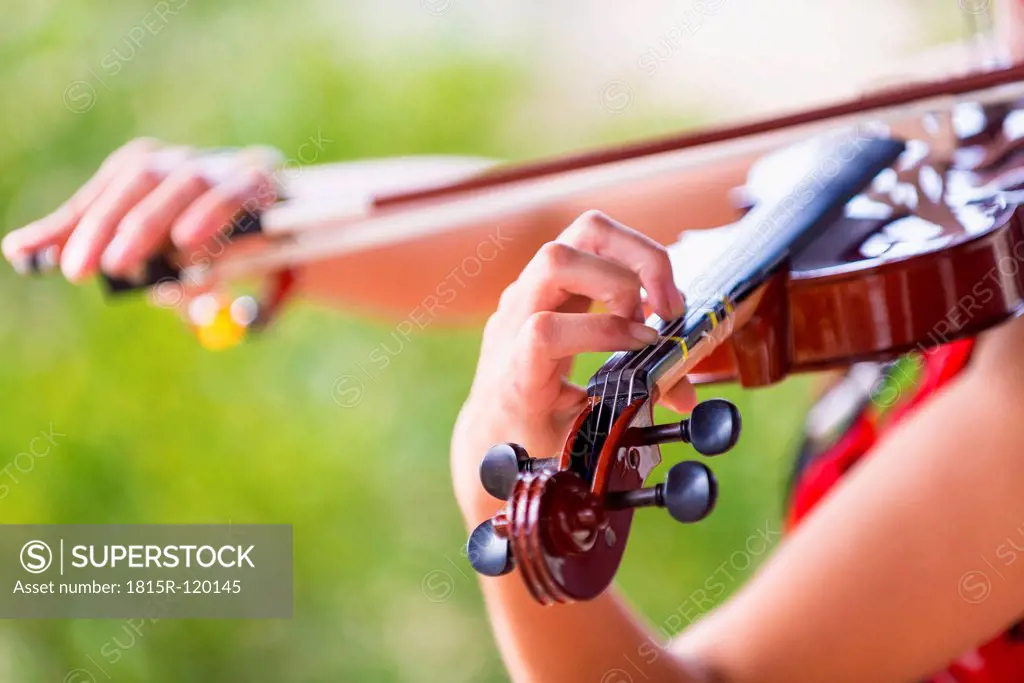USA, Texas, Young woman playing violin, close up