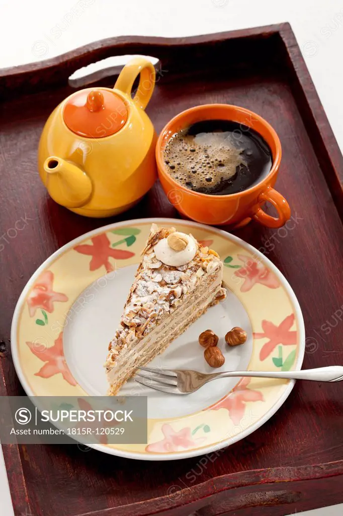 Slice of Noisette Cake with cup of coffee in tray