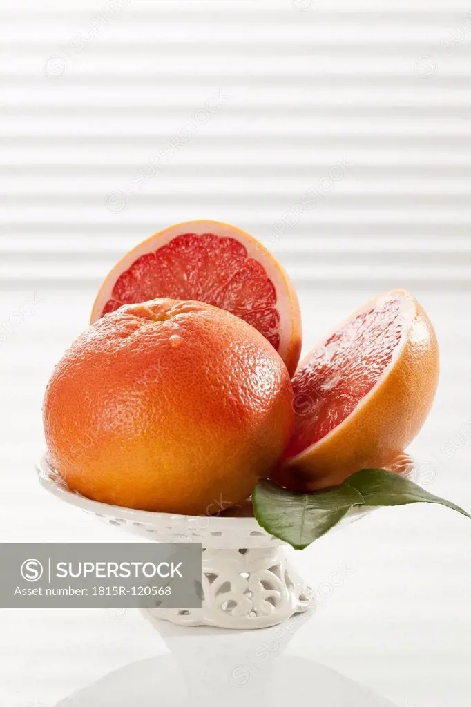 Grapefruit with leaf in fruit bowl, close up