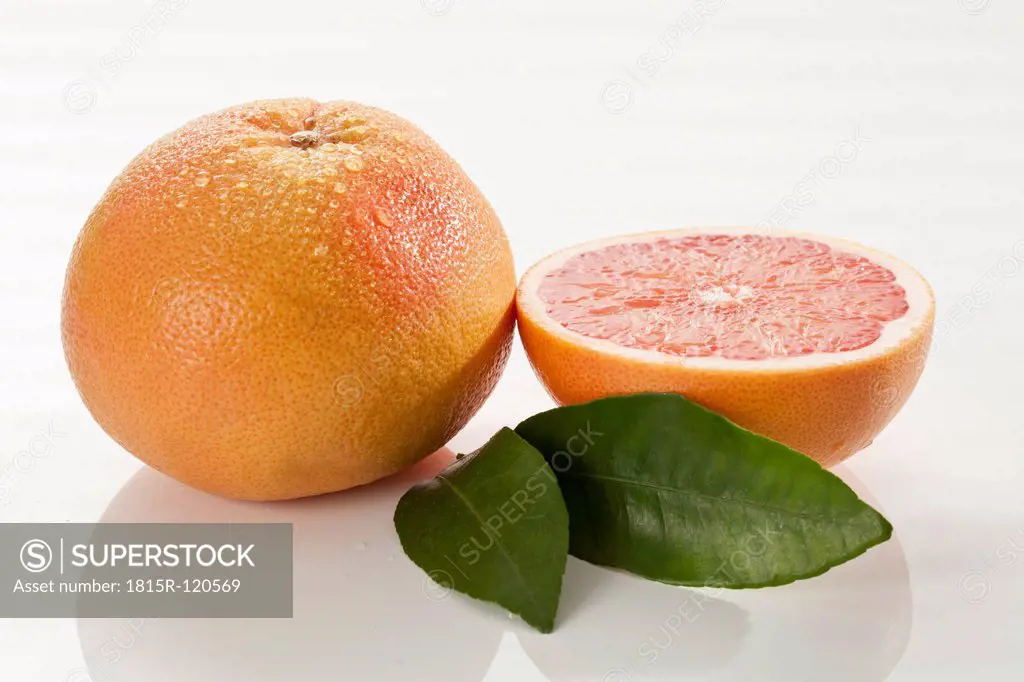 Grapefruit with leaf on white background, close up