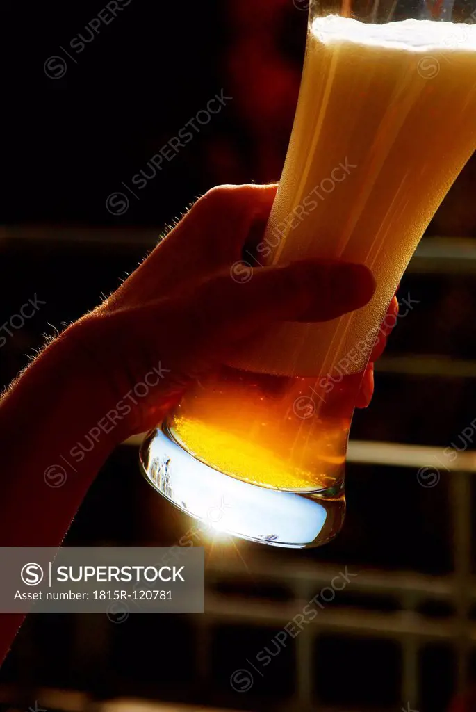 Germany, Bavaria, Human hand holding wheat beer glass, close up