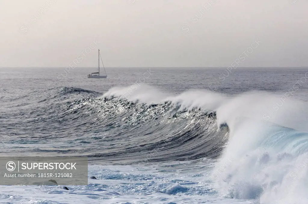 Spain, Breaking of waves, sailing boat in background at La Gomera