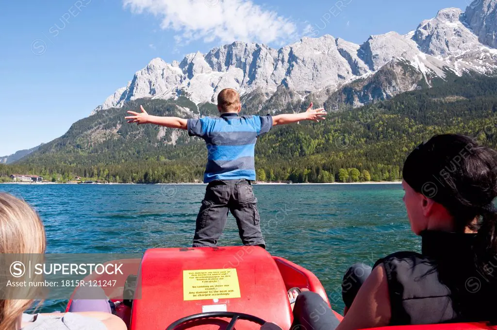 Germany, Bavaria, Family in paddleboat on Lake Eibsee with Wetterstein mountains in background
