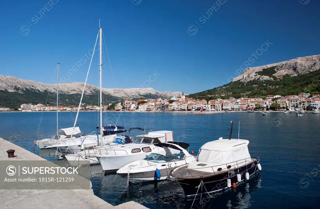 Croatia, Boat moored at harbour in Krk island with Baska town in background