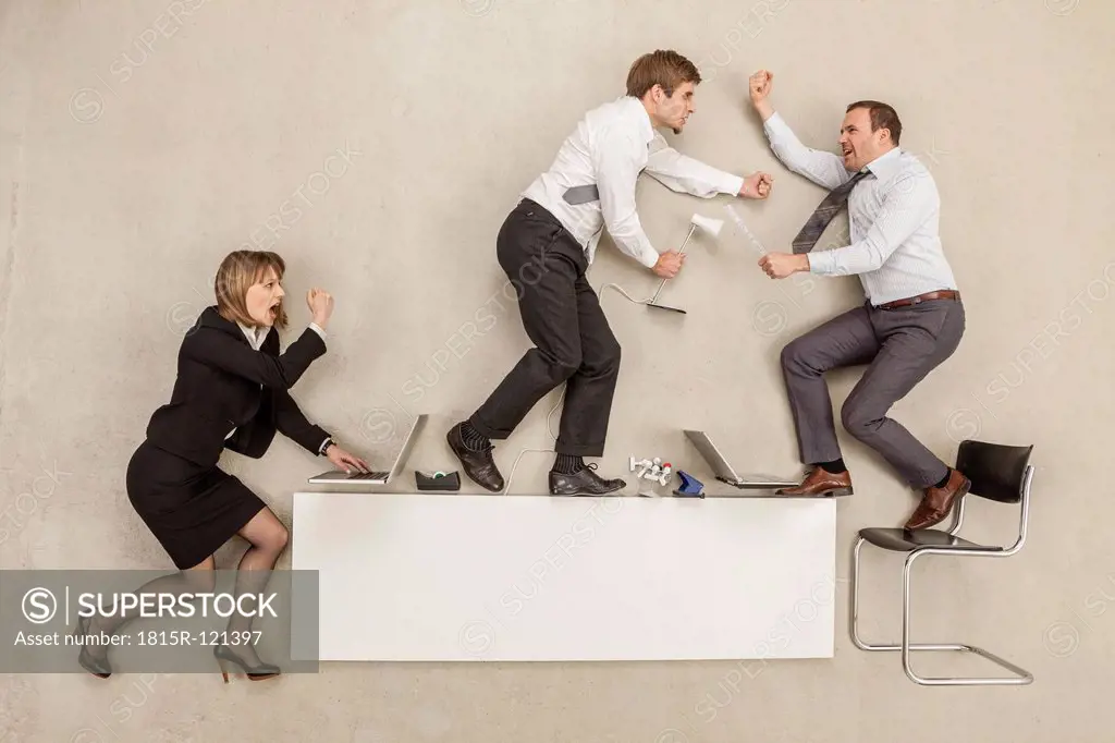 Business people fighting on office desk