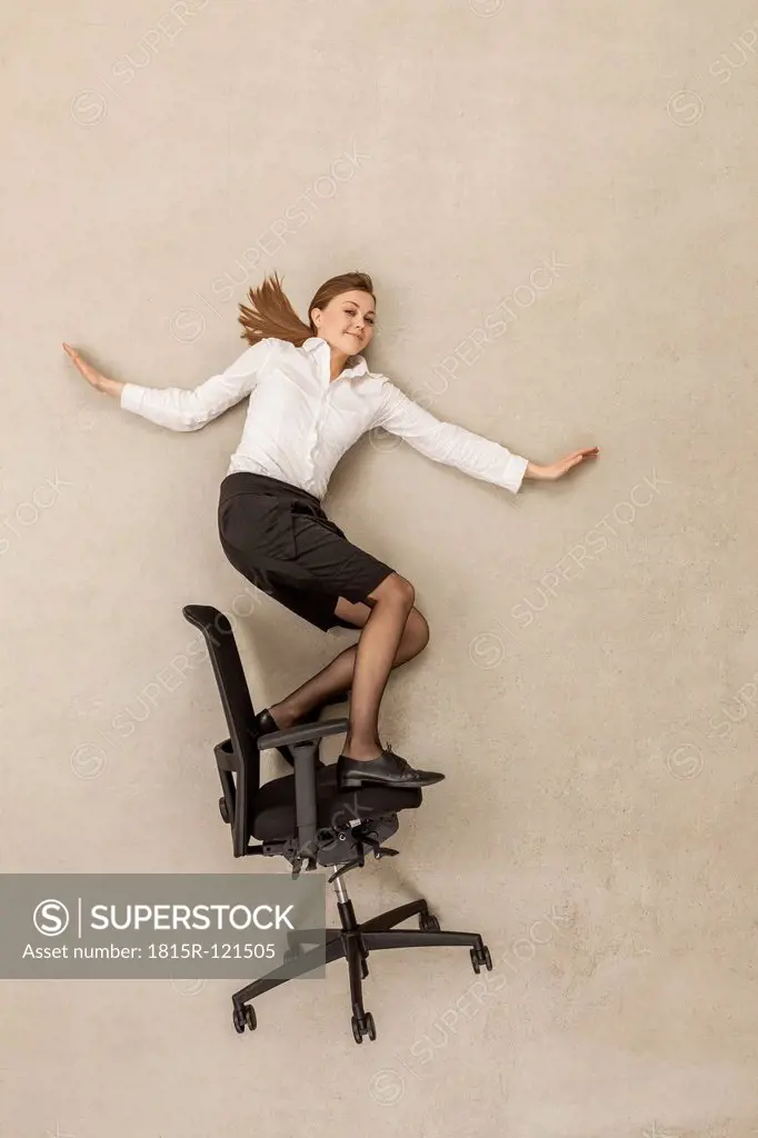 Businesswoman skating on office chair