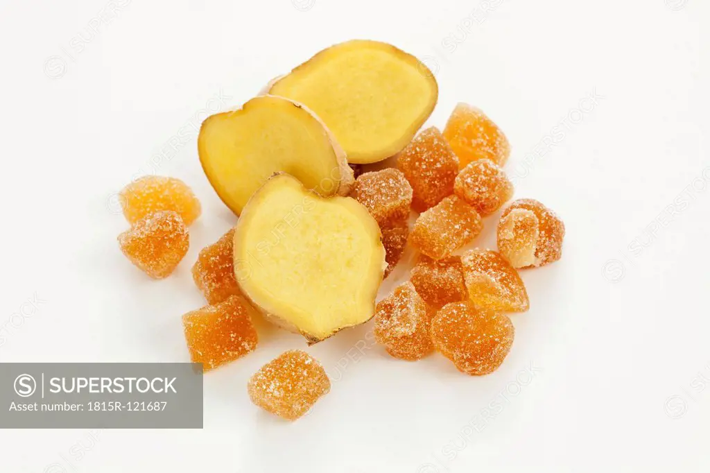 Sliced ginger and pieces of candied ginger on white background, close up