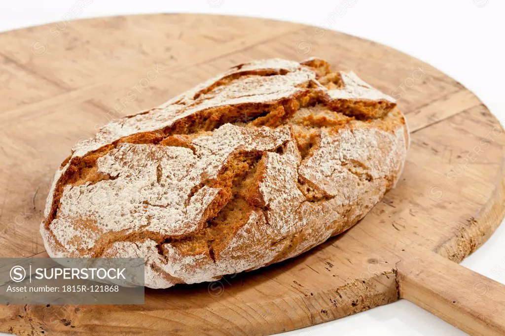 Crusty bread on chopping board, close up