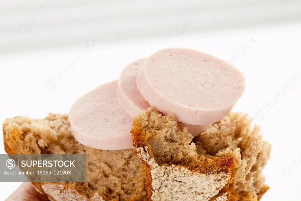 Slice of pork sausage with rye bread, close up