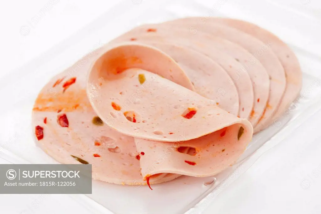 Mortadella sausage with paprika in tray, close up