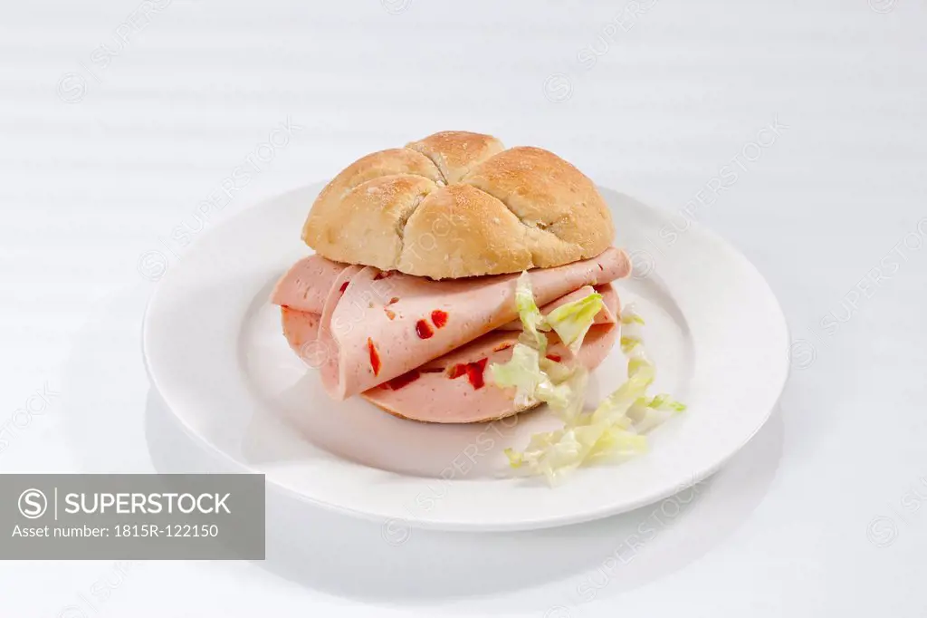 Sandwich of bread roll with mortadella and paprika on plate, close up