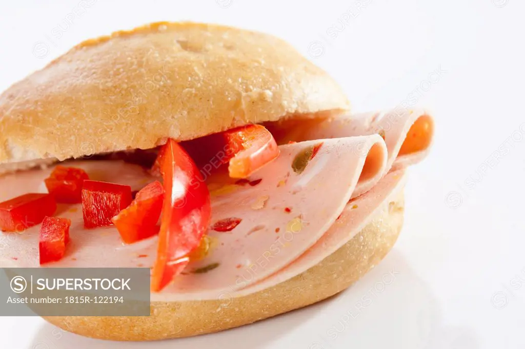 Sandwich of bread roll with mortadella and paprika on white background, close up