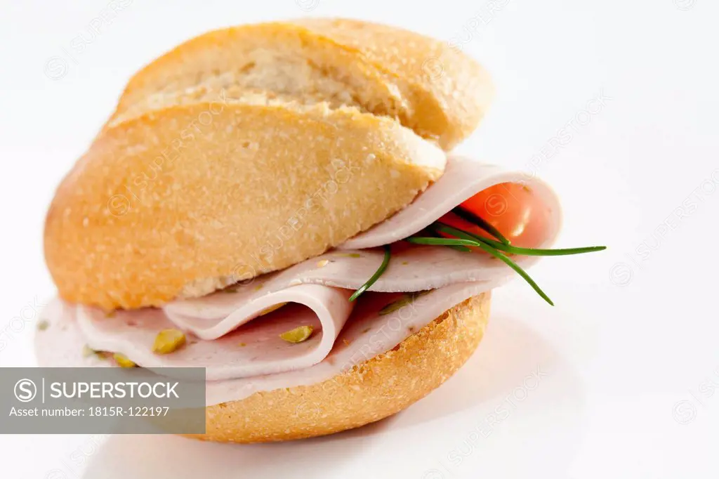 Sandwich of bread roll with mortadella and pistachio on white background, close up