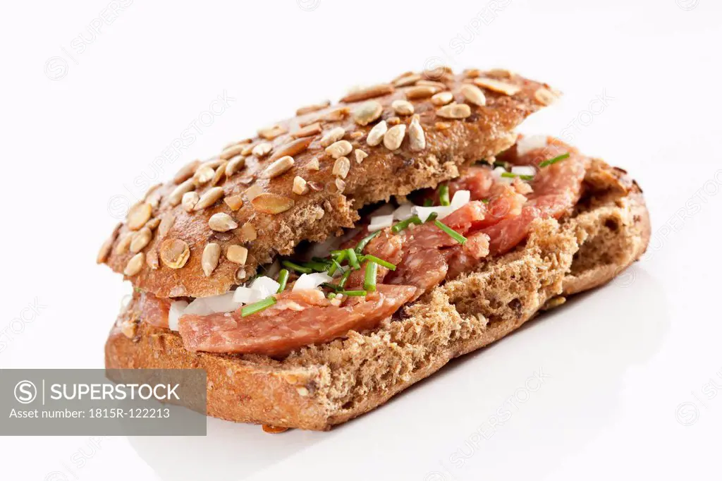 Sandwich of grain bread roll with ground ham on white background, close up