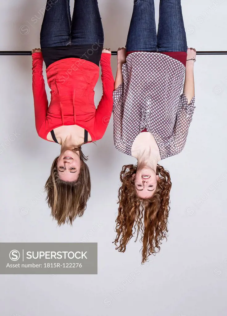 Young women hanging upside down, smiling