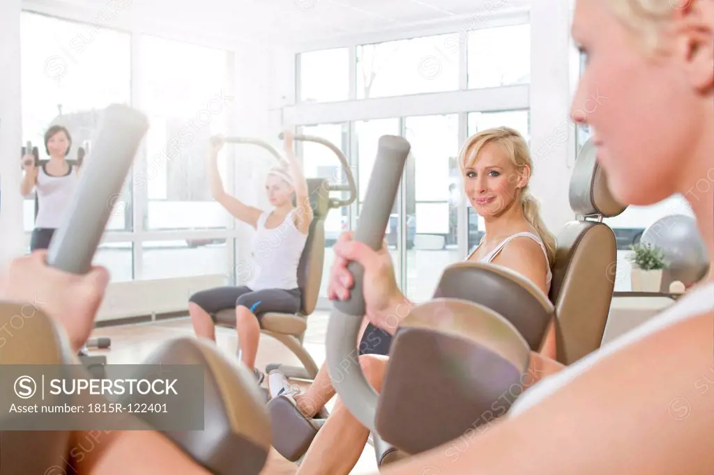 Germany, Brandenburg, Womens exercising in gym, smiling
