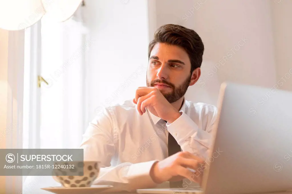 Businessman with laptop and cup of coffee