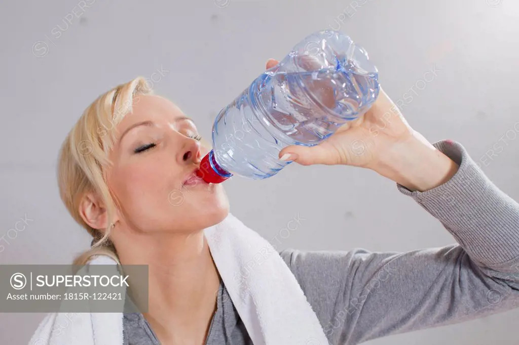 Germany, Brandenburg, Woman drinking water in gym