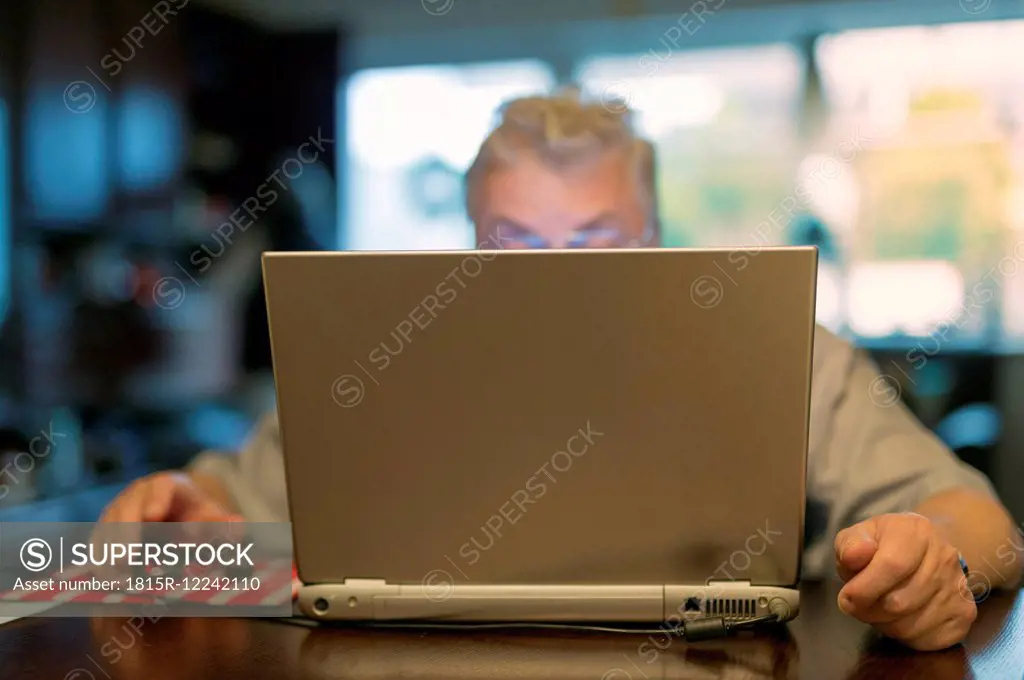 Portrait of senior man using laptop at home
