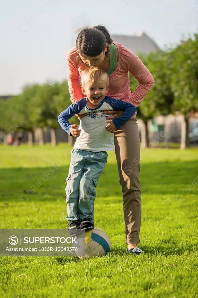 Mother and son with ball on meadow