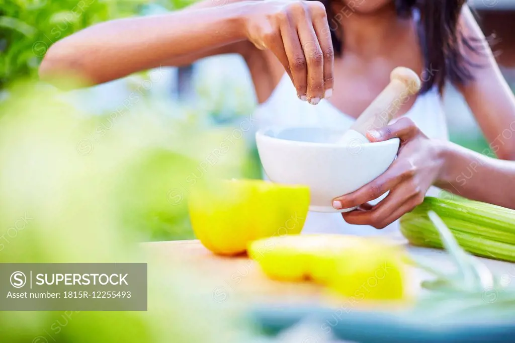 Young woman preparing healthy meal in garden