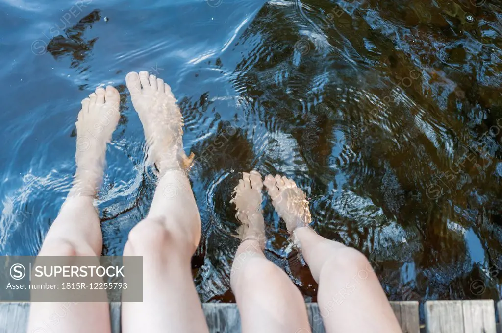 Finland, lake Saimaa, children splashing feet in water