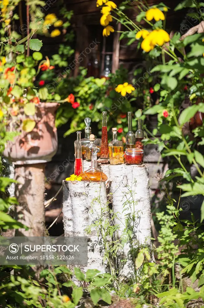 Austria, Salzburg, Bottles with herbal oils in garden