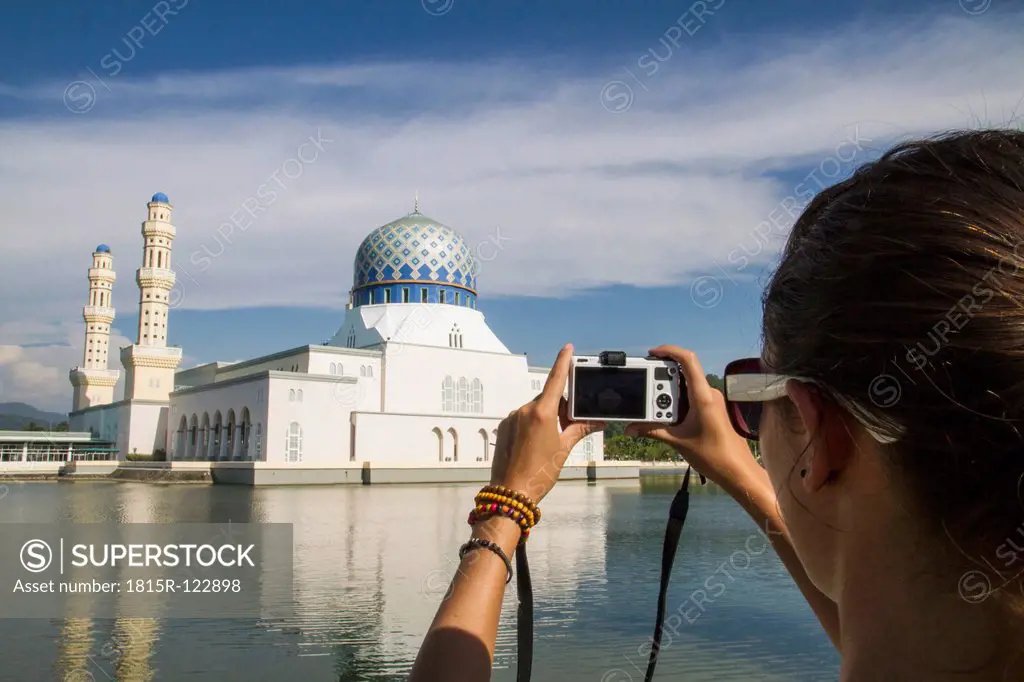 Malaysia, Borneo, Young woman taking photo of City Mosque in Kota Kinabalu