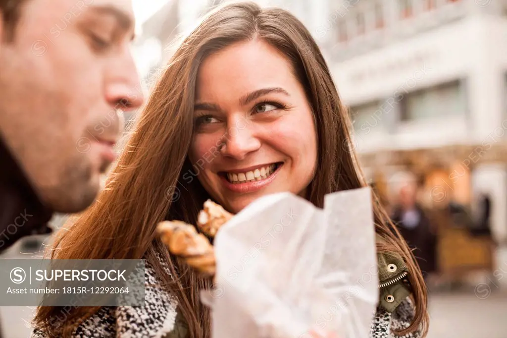 Germany, Cologne, young coupleeating pastry