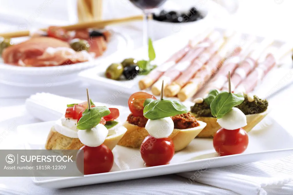Grissini with parma ham and olives and mozzarella with tomatoes, italian starters
