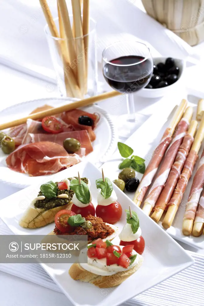 Grissini with parma ham and olives and mozzarella with tomatoes, italian starters