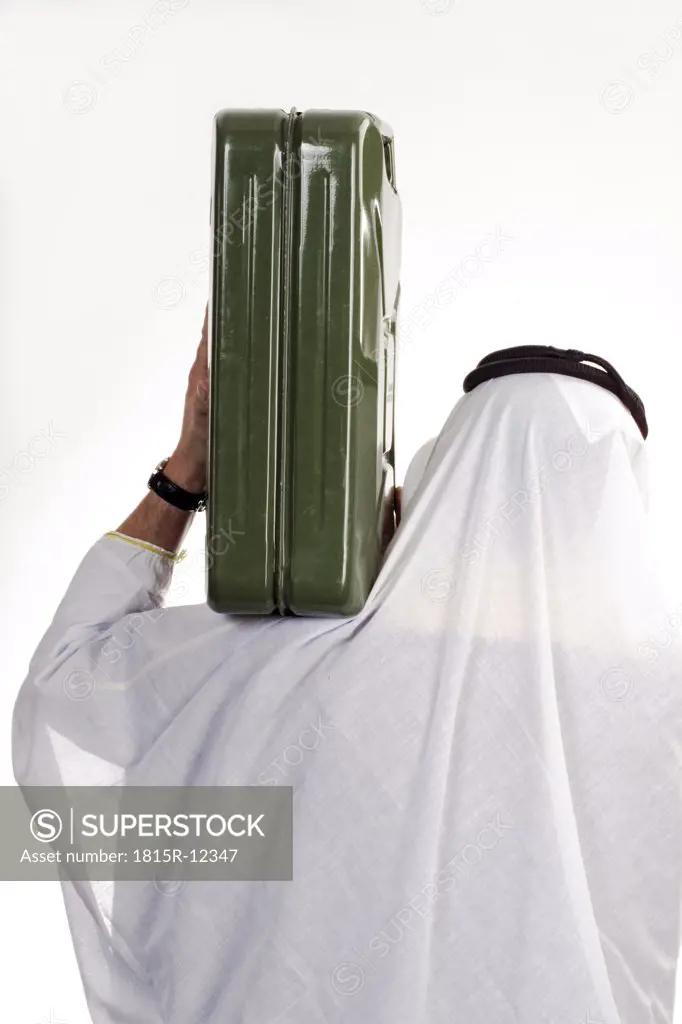 Man wearing traditional Arab dress, carrying petrol can on shoulder, rear view