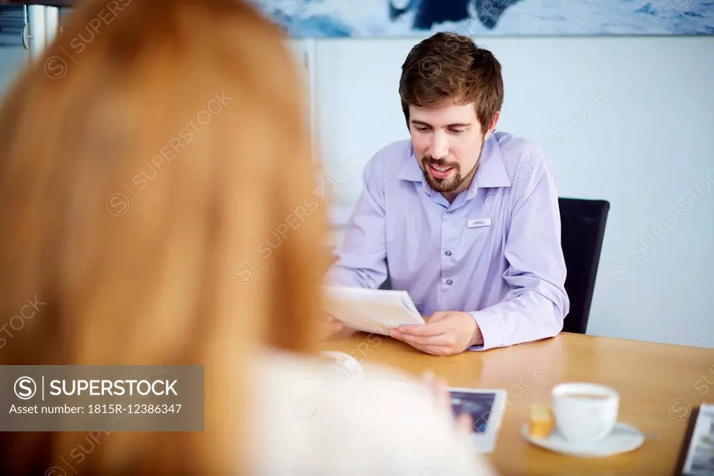 Salesman talking to woman in office