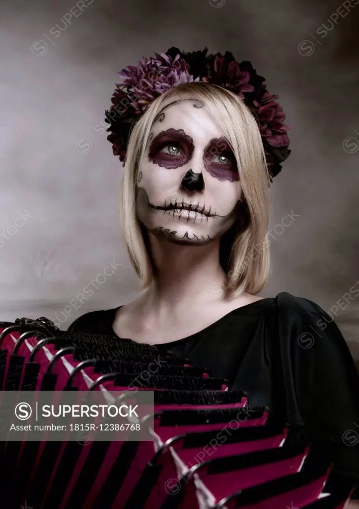 Portrait of woman with sugar skull makeup and accordion