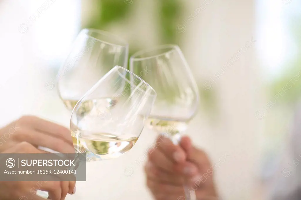 Hands holding glasses of white wine