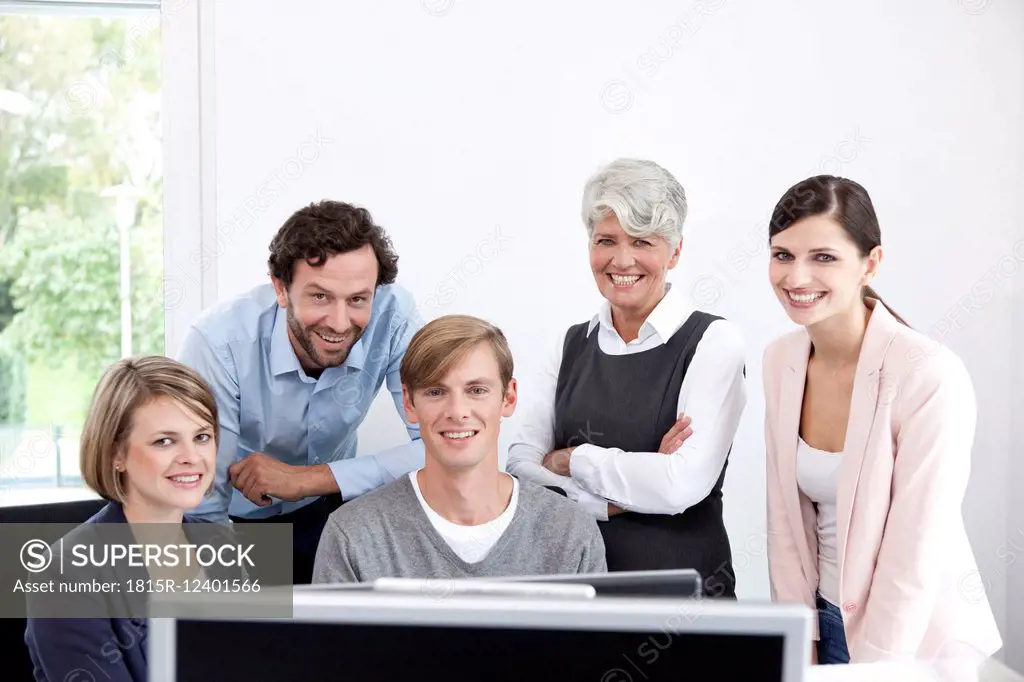 Smiling business team working on computer in office
